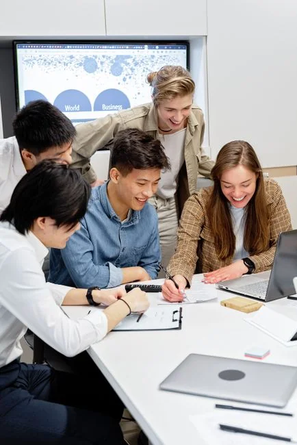 A varied team working together on digital marketing strategies at a desk, using laptops and tablets.